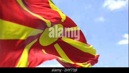 Detail der Nationalflagge Nordmazedoniens, die an einem klaren Tag im Wind winkt. Nord-Mazedonien ist ein Land in Südosteuropa. Selektiver Fokus. Stockfoto