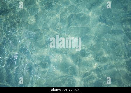 Hintergrundaufnahme der Wasseroberfläche des Aqua-Meeres mit Sonnenreflexionen Stockfoto