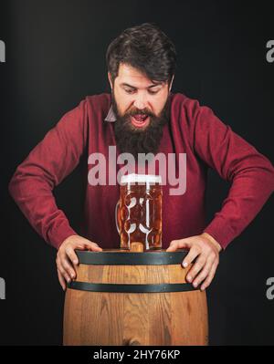 Biersorten und -Stile. Bier in Deutschland. Porträt eines hübschen jungen Mannes, der ein Bier vom Fass probiert. Deutschland - Bayern. Stockfoto
