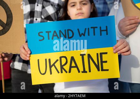 Kleines Kind mit einem Schild mit einer Unterstützungsbotschaft für das ukrainische Volk. Demonstration gegen den Krieg. Freie Ukraine. Stockfoto