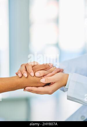 Jede Herausforderung ist ein gemeinsames Gesicht. Nahaufnahme eines nicht erkennbaren Arztes, der die Hand des Patienten bequem hält. Stockfoto
