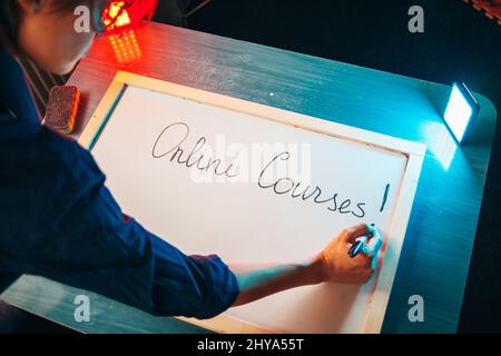 Draufsicht auf die Hand eines Lehrers mit dem Marker auf einem Whiteboard, dass Online-Unterricht beginnt. Online-Lifestyle. Online-Schulung. Stockfoto