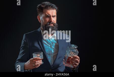 Trinkender Mann. Alkoholmissbrauch: Betrunkener Mann, der ein Glas Whiskey anschaut. Retro Vintage Mann mit Whiskey oder Scotch. Alkoholisches Konzept. Stockfoto