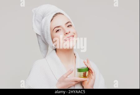 Gesichtsbehandlung. Glückliche Frau schlägt ein Kosmetikprodukt vor. Gesten für Werbung. Stockfoto