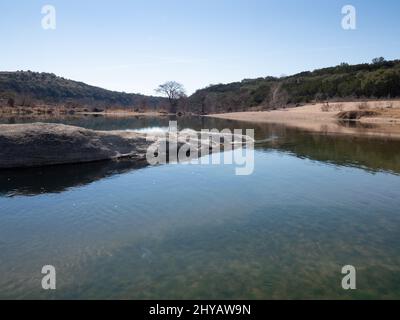 Pool mit klarem Wasser im Pedernales River mit einem Sandstrand und Kalksteinfelsen im Pedernales Falls State Park in Texas Stockfoto