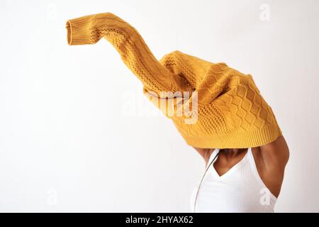 Seine Strickmode Saison. Studioaufnahme einer unkenntlichen Frau, die sich vor weißem Hintergrund anzieht. Stockfoto