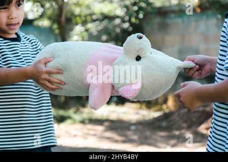 Zwei Schwestern in einem Streit um ein Spielzeug zu Hause. Geschwister Mädchen schnappen Puppe während zu Hause bleiben. Beziehungen Schwierigkeiten im Familienkonzept Stockfoto