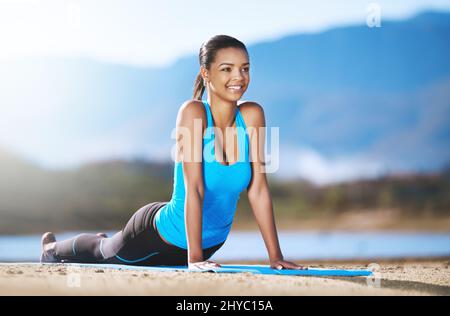 Nehmen Sie sich Zeit, um zu tun, was Ihre Seele glücklich macht. Aufnahme einer jungen Frau, die im Freien Yoga praktiziert. Stockfoto