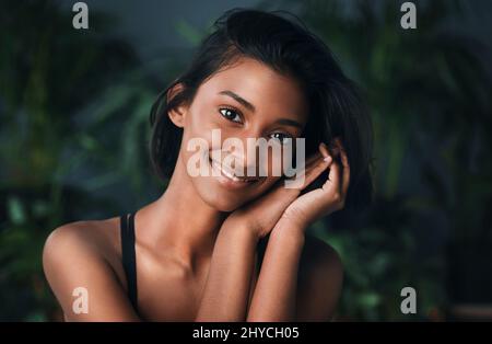 Reine Schönheit liegt darin, dein einzigartiges selbst zu sein. Aufnahme einer schönen jungen Frau, die vor einem dunklen Hintergrund posiert. Stockfoto