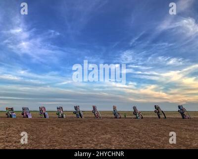 Cadillac Ranch ist keine Ranch, sondern eine öffentliche Kunstinstallation und Skulptur in Amarillo, Texas, USA. Gebrauchte Cadillac-Automobile sind halb vergraben Nase-zuerst im Boden, in einem Winkel, der dem der Großen Pyramide von Gizeh in Ägypten entspricht, und zeigen die verschiedenen Arten von Schwanzflossen. Die Cadillac Ranch ist von der Autobahn, an der Route 66, aus zu sehen. Das Hotel liegt auf privatem Land, ist der Besuch erwünscht. Außerdem wird das Schreiben von Graffiti auf den Fahrzeugen oder das Lackieren der Fahrzeuge gefördert. Jedes Mal, wenn Sie hier sind, ist es eine andere Erfahrung, denn sie verändert sich ständig Stockfoto