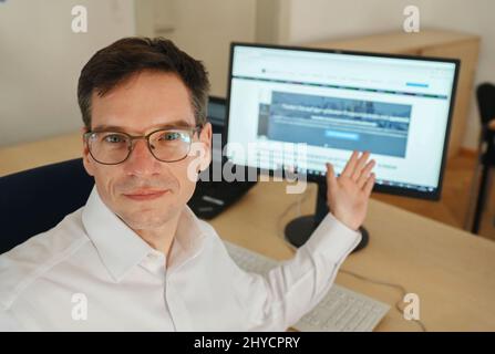 Karlsruhe, Deutschland. 01. März 2022. Dieter Abstein, Abteilungsleiter 3,1 - Wirtschaftskriminalität bei der Polizeidirektion Karlsruhe, zeigt auf einem Monitor die Website einer Handelsplattform, die ohne Genehmigung in sogenannten Differenzverträgen handelt. Die Bundesanstalt für Finanzdienstleistungsaufsicht (BaFin) hat das Handeln der Plattform untersagt. (To dpa 'Melken der Kuh' - betrügerische Finanzagenten sammeln Millionen) Credit: Uli Deck/dpa/Alamy Live News Stockfoto