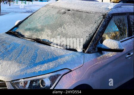 Die Windschutzscheibe war an einem sonnigen Wintertag mit Frost bedeckt Stockfoto