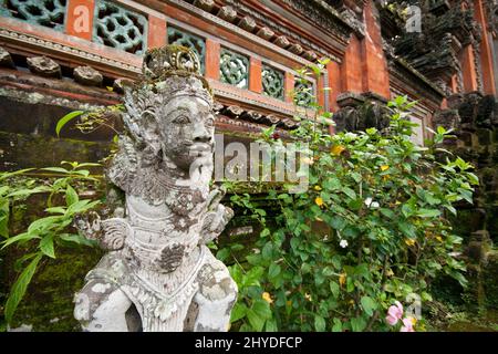 Nahaufnahme einer alten und verwitterten Steinstatue vor einem alten Gebäude in Ubud, Bali, Indonesien. Stockfoto