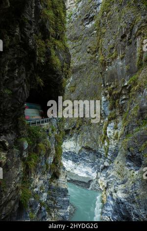 Steile und hohe Felswände, tiefe Schlucht, Fluss und kleine Straße, die an der Schwalbe Grotto (Yanzikou) im Taroko-Nationalpark in Taiwan am Felskante gegraben wurde Stockfoto