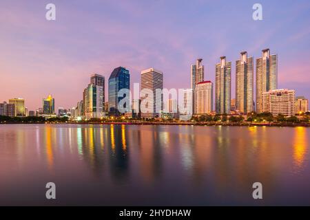 Malerischer Blick auf See an der Benjakiti (benjakitti) Park und Wolkenkratzer in Bangkok, Thailand, bei Sonnenuntergang. Stockfoto