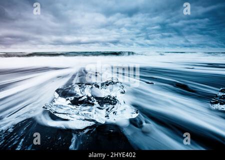 Große Stücke des Eisbergs, die Funkeln auf dem schwarzen Sand. Malerische und schöne Szene. Lage berühmte Ort Jokulsarlon Lagune, Vatnajökull nati Stockfoto