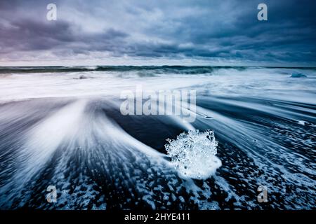 Große Stücke des Eisbergs, die Funkeln auf dem schwarzen Sand. Malerische und schöne Szene. Lage berühmte Ort Jokulsarlon Lagune, Vatnajökull nati Stockfoto