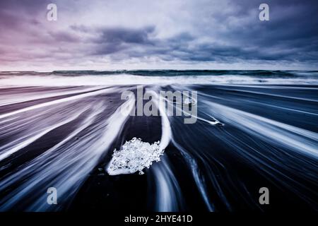 Große Stücke des Eisbergs, die Funkeln auf dem schwarzen Sand. Malerische und schöne Szene. Lage berühmte Ort Jokulsarlon Lagune, Vatnajökull nati Stockfoto