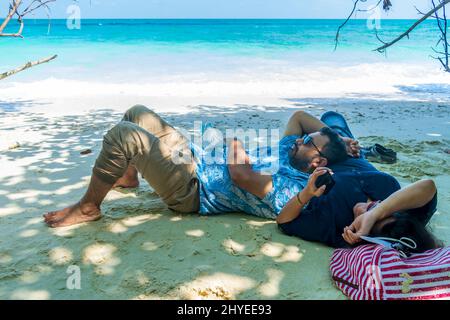 Ein Paar, das sich am Strand, Havelock Island, Andaman, Indien, erholte Stockfoto