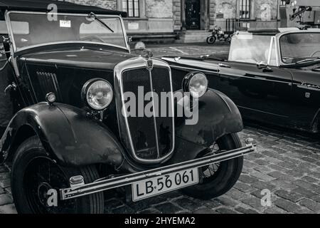 Graustufenaufnahme der Ausstellung alter Oldtimer in den Straßen von Kopenhagen, Dänemark Stockfoto