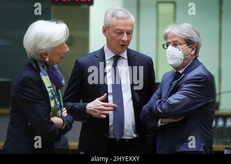 Brüssel, Belgien. 14. März 2022. Christine Lagarde (L), die Präsidentin der Europäischen Zentralbank (EZB), Bruno Le Maire (C), der französische Wirtschaftsminister und Paolo Gentiloni, der für Wirtschaft zuständige EU-Kommissar, sprechen während einer Sitzung der Eurogruppe am 14. März 2022 in Brüssel, Belgien. Der Euroraum wird die Auswirkungen des Russland-Ukraine-Konflikts auf seine Wirtschaft abmildern, indem er die Situation genau überwacht und seine Fiskalpolitik bei Bedarf umgehend anpasst, sagten Beamte am Montagabend nach einem Treffen der Eurogruppe. Quelle: Zheng Huansong/Xinhua/Alamy Live News Stockfoto