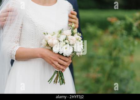 Details des Hochzeitstages. Brautstrauß in den Händen der Braut Stockfoto