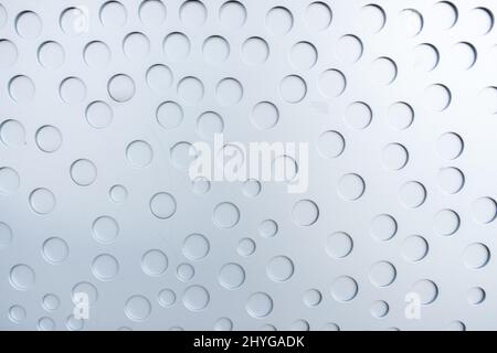 Matte Metalloberfläche mit gestanzten runden, nicht durchgestanzten Löchern Stockfoto