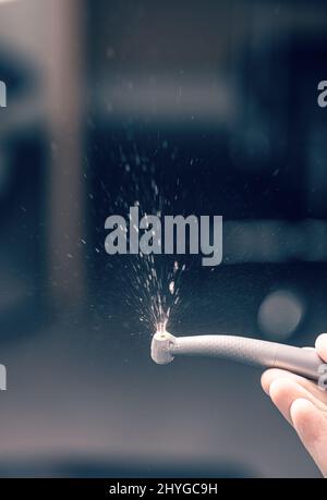 Zahnarzthand mit Zahnbohrmaschine mit Wasser. Stockfoto