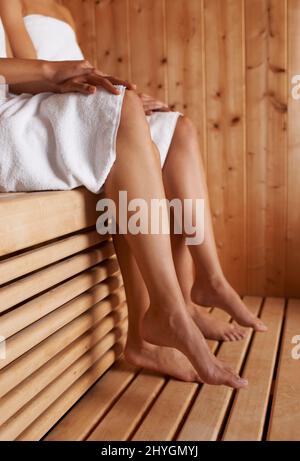 Genießen Sie die Sauna. Zugeschnittenes Bild von zwei Freunden, die zusammen in der Sauna sitzen. Stockfoto