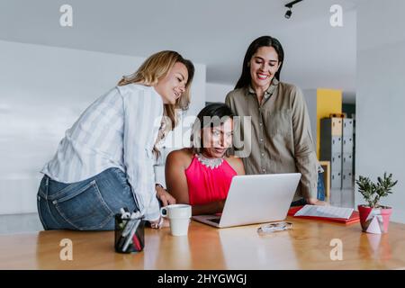 Transgender latin Woman, die mit weiblichen Mitarbeitern im Büro in Mexiko Lateinamerika arbeitet Stockfoto