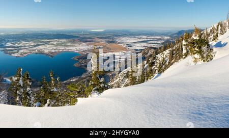 Blick auf den Kochelsee und die Ausläufer der Alpen bei München. Blick vom Mt. Jochberg am Walchensee im Winter in den bayerischen Alpen. Stockfoto
