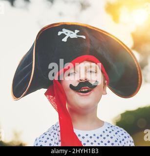 Yo ho, yo ho, ein Piratenleben für mich. Porträt eines niedlichen kleinen Jungen, der draußen posiert, während er sich wie ein Pirat verkleidet. Stockfoto