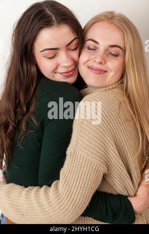 Zwei junge Freundinnen umarmen sich Stockfoto