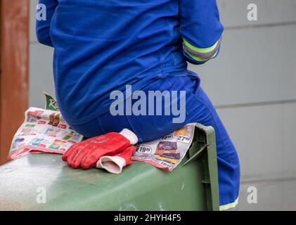 Johannesburg, Südafrika - eine nicht identifizierte schwarze Müllsammlerin sitzt auf einem Abfalleimer, der zwischen den Sammlungen ruht Stockfoto
