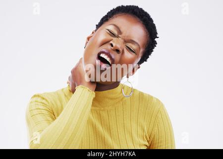 Sieht aus wie eine Halsentzündung. Studioaufnahme einer jungen Frau mit Halsschmerzen vor grauem Hintergrund. Stockfoto