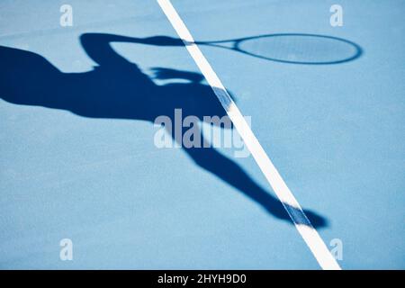 Der Schatten eines Gewinners. Ein Schatten eines Tennisspielers bereit zu dienen. Stockfoto