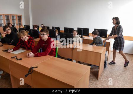 Ostrava, Tschechische Republik. 15. März 2022. Kinder aus der vom Krieg zerrissenen Ukraine am 15. März 2022 in einem der Klassenräume der Nadrazni-Grundschule in Ostrava, Tschechien. Auf der rechten Seite ist Koordinatorin Oksa Bilik zu sehen. Kredit: Jaroslav Ozana/CTK Foto/Alamy Live Nachrichten Stockfoto