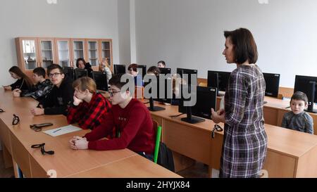 Ostrava, Tschechische Republik. 15. März 2022. Kinder aus der vom Krieg zerrissenen Ukraine am 15. März 2022 in einem der Klassenräume der Nadrazni-Grundschule in Ostrava, Tschechien. Auf der rechten Seite ist Koordinatorin Oksa Bilik zu sehen. Kredit: Jaroslav Ozana/CTK Foto/Alamy Live Nachrichten Stockfoto