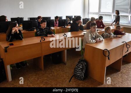 Ostrava, Tschechische Republik. 15. März 2022. Kinder aus der vom Krieg zerrissenen Ukraine am 15. März 2022 in einem der Klassenräume der Nadrazni-Grundschule in Ostrava, Tschechien. Auf der rechten Seite ist Koordinatorin Oksa Bilik zu sehen. Kredit: Jaroslav Ozana/CTK Foto/Alamy Live Nachrichten Stockfoto