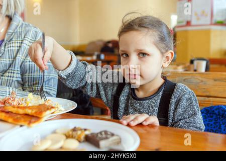 USCHHOROD, UKRAINE - 14. MÄRZ 2022 - Ein Mädchen isst in einem Restaurant, das Binnenvertriebenen, die vor der russischen Invasion fliehen, kostenlose Mahlzeiten anbietet, Uschhorod, Region Zakarpattia, Westukraine. Foto von Hudak Serhii/Ukrinform/ABACAPRESS.COM Stockfoto