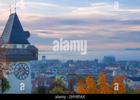 Stadtbild von Graz und dem berühmten Grazer Uhrturm auf dem Schlossberg, Graz, Steiermark, Österreich, im Herbst, Bei Sonnenaufgang Stockfoto