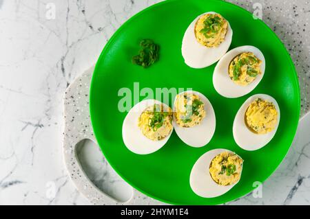 Gefüllte Eier liegen auf dem Tisch, auf dem Brett. Stockfoto