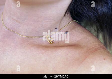 Nahaufnahme einer Halskette mit einem Krebskonstellationszeichen am Hals einer hispanischen Frau. Stockfoto