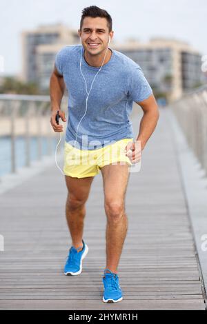 Sportliche Mann tun workout Übungen und Musik im Freien Stockfoto