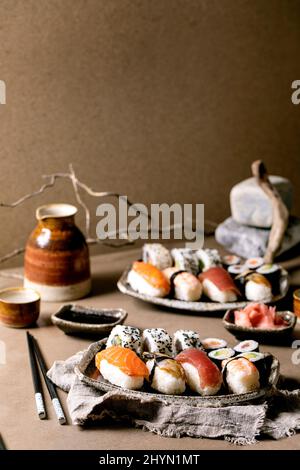 Sushi-Brötchen für zwei Personen. Traditionelles japanisches Sushi und Brötchen mit frischem Lachs, Thunfisch, Aal und Garnelen auf Reis. Auf Tellern mit Sojasauce A servieren Stockfoto