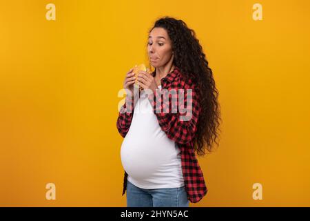 Lustig Schwanger Latin Lady Holding Burger Sandwich Im Studio Stockfoto