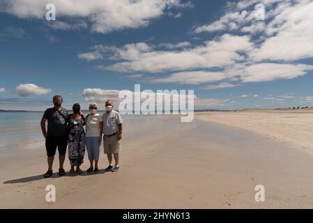 Langabaan, Westküste, Südafrika. 2022. Eine Gruppe älterer Urlauber, die während der Zwangsbeschränkungen Masken am Strand tragen. Stockfoto