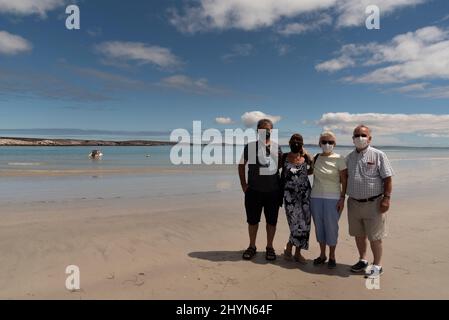 Langabaan, Westküste, Südafrika. 2022. Eine Gruppe älterer Urlauber, die während der Zwangsbeschränkungen Masken am Strand tragen. Stockfoto