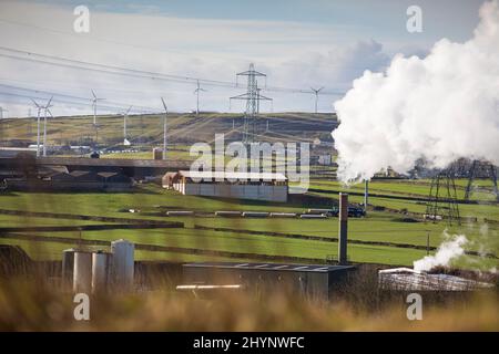 Dampfpumpen aus dem Kamin der Robinson- und Mitchells-Fabrik in der Nähe von Thornton, Bradford, England, West Yorkshire, Großbritannien. Dampf ist Wasser in der Gasphase. Dies kann durch Verdunstung oder durch Sieden auftreten, bei dem Wärme aufgebracht wird, bis das Wasser die Enthalpie der Verdampfung erreicht. Gesättigter oder überhitzter Dampf ist unsichtbar; „Team“ bezieht sich jedoch häufig auf nassen Dampf, den sichtbaren Nebel oder Aerosol von Wassertropfen, die sich aus der Kondenierung von Wasserdampf bilden. Kredit: Windmill Images/Alamy Live Nachrichten Stockfoto