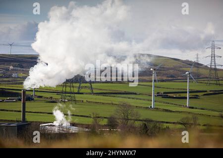 Dampfpumpen aus dem Kamin der Robinson- und Mitchells-Fabrik in der Nähe von Thornton, Bradford, England, West Yorkshire, Großbritannien. Dampf ist Wasser in der Gasphase. Dies kann durch Verdunstung oder durch Sieden auftreten, bei dem Wärme aufgebracht wird, bis das Wasser die Enthalpie der Verdampfung erreicht. Gesättigter oder überhitzter Dampf ist unsichtbar; „Team“ bezieht sich jedoch häufig auf nassen Dampf, den sichtbaren Nebel oder Aerosol von Wassertropfen, die sich aus der Kondenierung von Wasserdampf bilden. Kredit: Windmill Images/Alamy Live Nachrichten Stockfoto